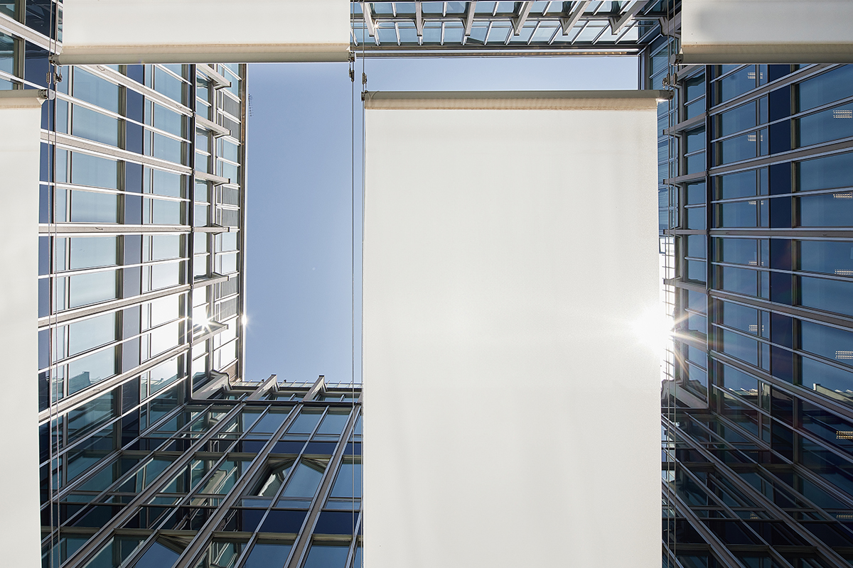 Tenda da sole bianca rettangolare installata nella corte esterna del Palazzo Assolombarda